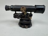 un vieux télescope posé sur un trépied, sur une surface blanche