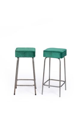 two green stools sitting next to each other on a white surface