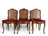 quatre chaises avec des coussins rouges et des coussins de dossier en rotin