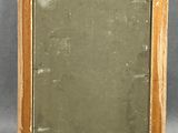 an old wooden frame with a mirror in it on a gray surface