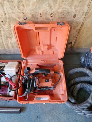 une boîte à outils orange posée par terre, contenant des outils
