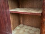a wooden cabinet with a door open on a hard wood floor