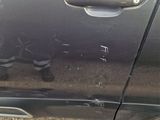 the door handle of a black car with a hole in it