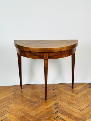 une photo d'une table en bois au plateau incurvé, posée sur un parquet