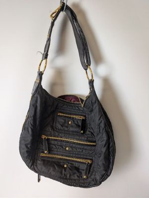 Le sac à main noir est accroché à un crochet au mur.