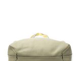 a close up of a beige leather bag on a white background