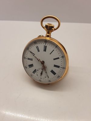 une petite montre de poche en or avec des chiffres romains