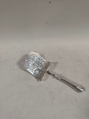 une cuillère en argent posée sur un évier blanc