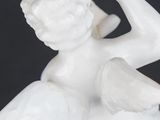 a white statue of an angel holding a baseball bat