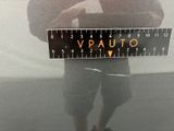 a man standing in front of a car holding a ruler