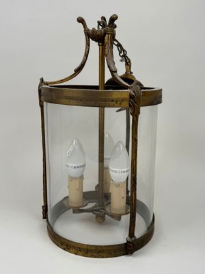 an antique brass lantern with two lamps inside of it on a white background