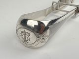 a silver spoon with a metal handle on a white surface