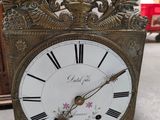 a clock that is sitting on the floor in front of a mirror
