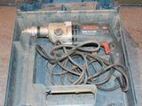 une perceuse dans une boîte à outils, avec un cordon à l'intérieur