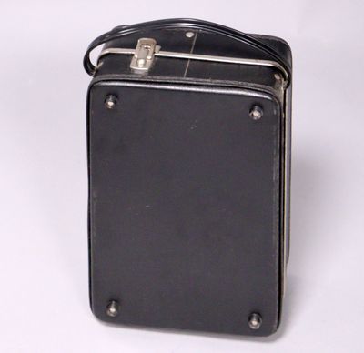 an old black suitcase sitting on top of a white surface