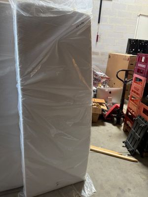 a large white mattress sitting on top of a pallet in a warehouse