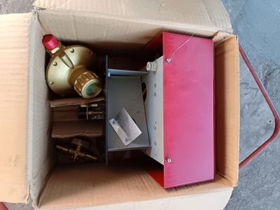 une boîte remplie d'objets hétéroclites posée sur le sol