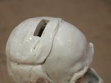 a white sculpture of a man ' s head on a table