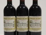 three bottles of red wine are lined up on a white surface