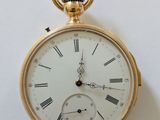 une montre de poche en or avec des chiffres romains sur le cadran