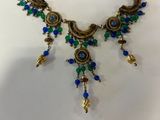 a close up of a necklace with blue and green beads