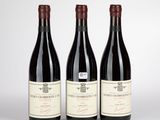 trois bouteilles de vin rouge posées côte à côte sur une table