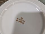une personne tenant une assiette blanche bordée d'or