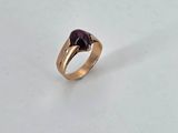 an image of a gold ring with a purple stone in the middle