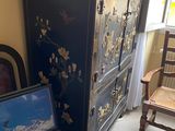 une armoire et une chaise dans une pièce près d'une fenêtre