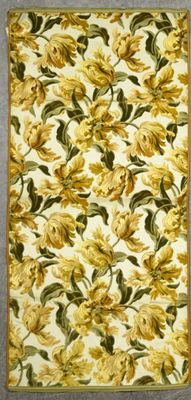 a yellow and green rug with a floral design on it