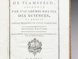 un livre ouvert posé sur une table à côté d'une tasse de café
