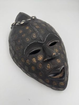 une image représentant un masque noir parsemé de points dorés
