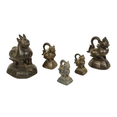 three bronze figurines of animals and a bird on a white background
