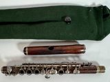 a flute that is sitting next to a green bag