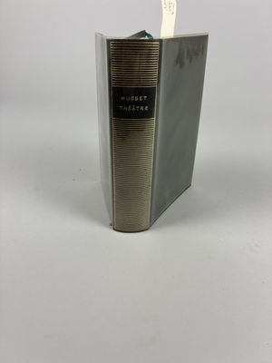 an old book with a pen sticking out of it sitting on a table