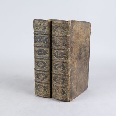 deux vieux livres posés l'un sur l'autre sur une surface blanche