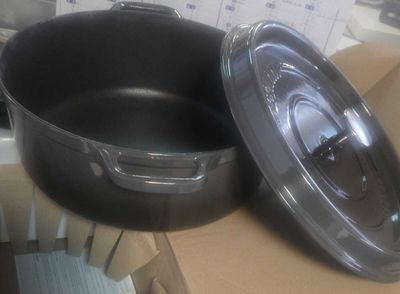 des casseroles et des poêles posées sur une boîte en carton posée sur une table