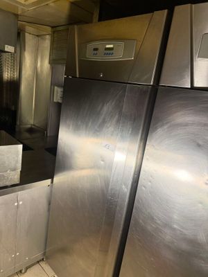 a stainless steel refrigerator in a kitchen next to a sink