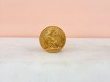 a gold coin sitting on top of a marble counter top