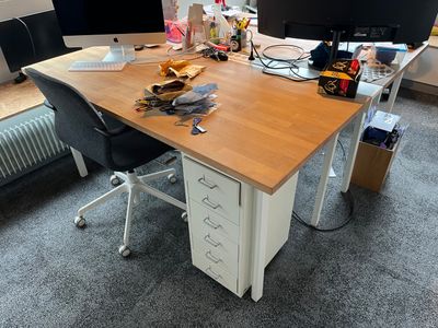 a desk with two monitors and a chair in front of it