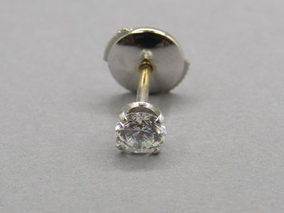 gros plan d'un diamant unique sur une surface blanche