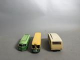 trois petits bus en plastique posés les uns à côté des autres sur une table