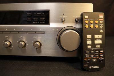 a remote next to a stereo system on a table