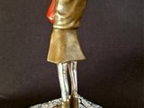 statue of a woman holding a red flower in her hand
