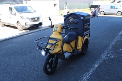 un scooter jaune et noir garé sur le bord de la route