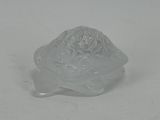 a glass turtle that is sitting on a white surface