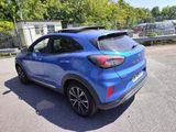 the rear end of a blue car parked in a parking lot