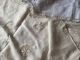 a bed with white linens and lace on it