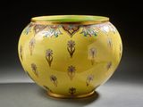 un vase jaune orné d'un motif floral