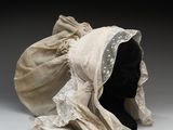 un chapeau blanc orné d'un voile, posé sur une tête de mannequin